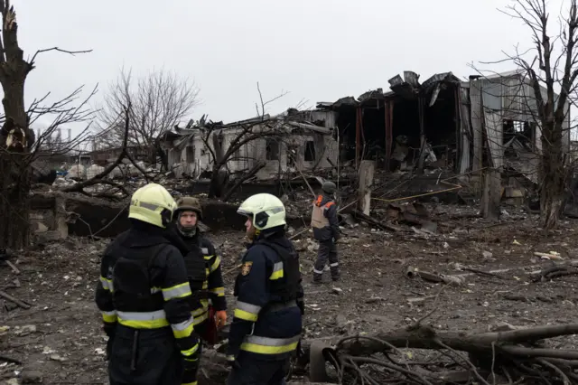 Rescue workers next to a destroyed building in Kharkiv, Ukraine