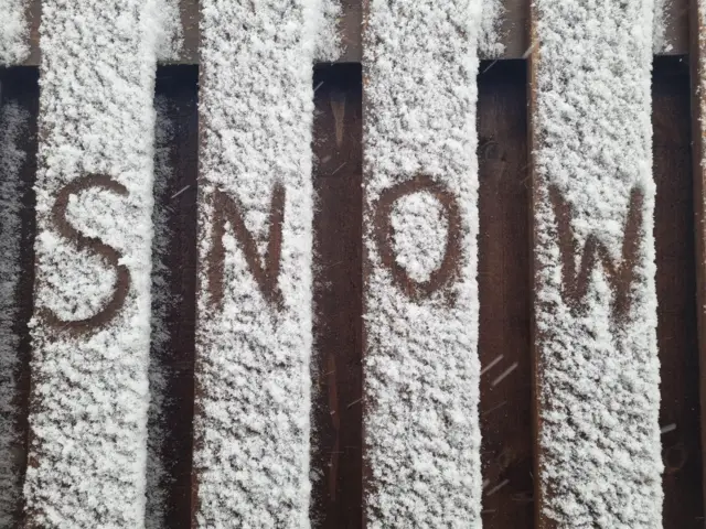 Snow writing on bench