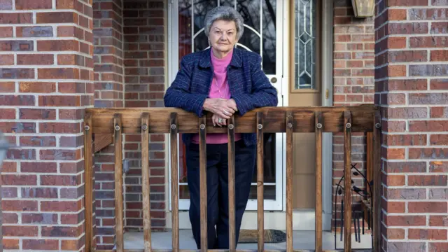 Norma Anderson standing on porch