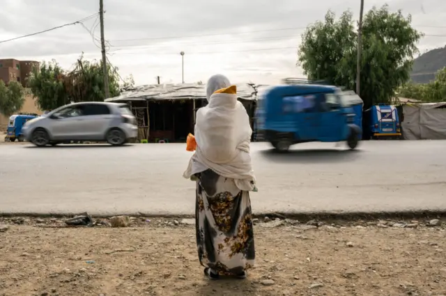 A woman waits by the roadside in Mekelle, Tigray region.