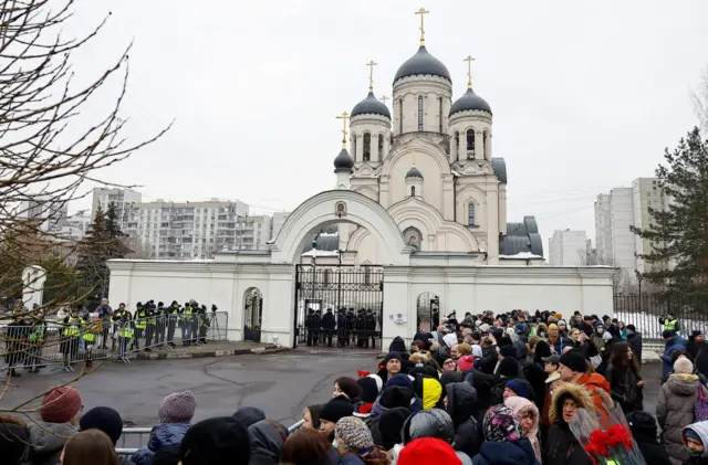 People wait outside the church in Moscow where Alexei Navalny is expected to be buried