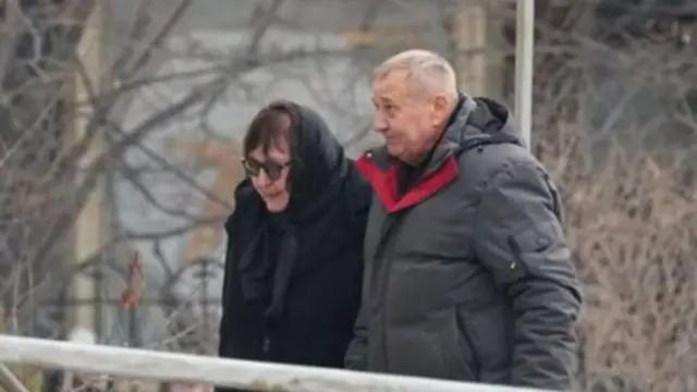 Alexei Navalny's parents, Liudmila and Anatoliy, walk to attend their son's funeral service in Moscow