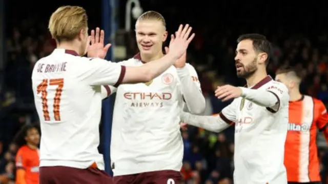 Kevin De Bruyne and Bernardo Silva celebrate with Erling Haaland