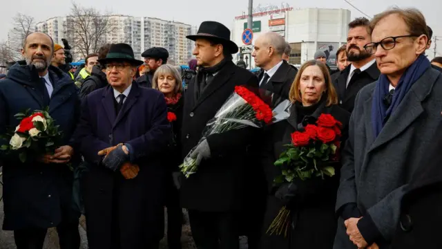 The French and American ambassadors to Russia stand with red roses near the Soothe My Sorrows church before a funeral service and a farewell ceremony for Russian opposition politician Alexei Navalny