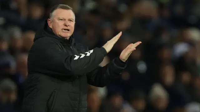 Mark Robins claps his hands on the touchline