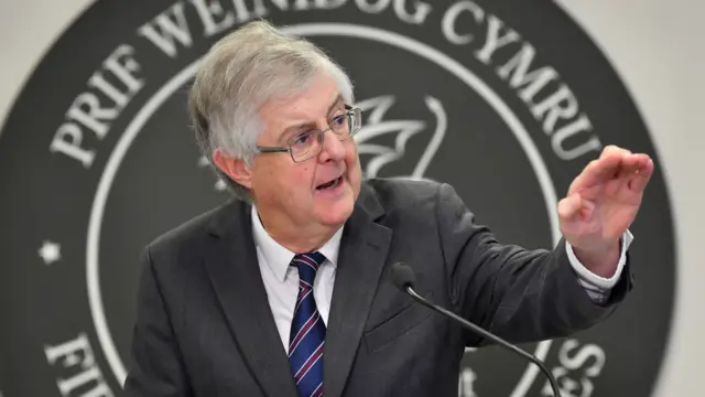 Mark Drakeford standing at a lectern during a Welsh government press conference