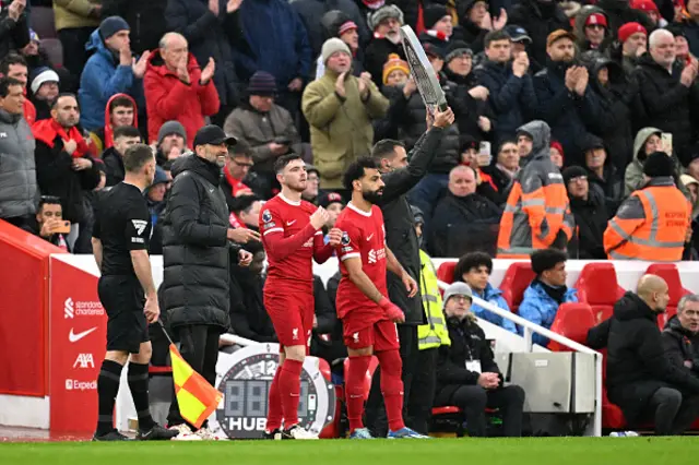 ndrew Robertson and Mohamed Salah of Liverpool prepare to be substituted on