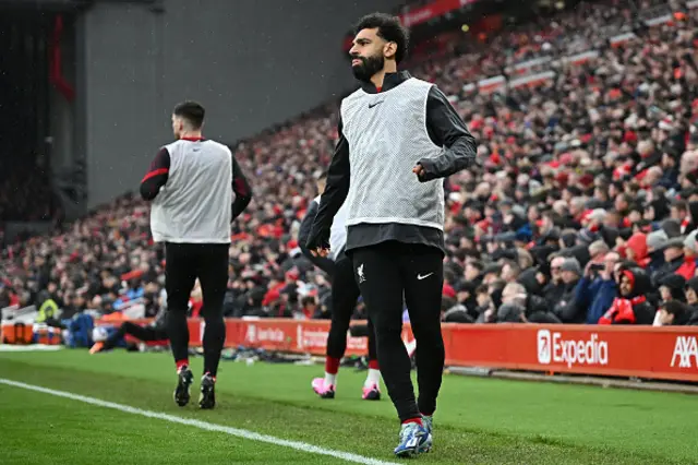 Mohamed Salah warms up on the sideline