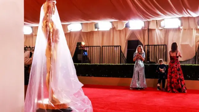 An Oscar statue is covered in plastic as preparations continue for the 96th Academy Awards in Los Angeles, California, U.S., March 9, 2024