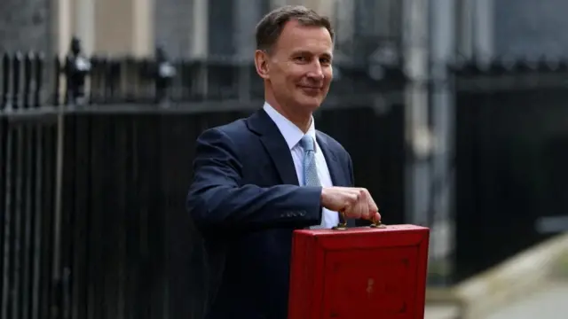 Jeremy Hunt stands outside No 11 holding up a red briefcase