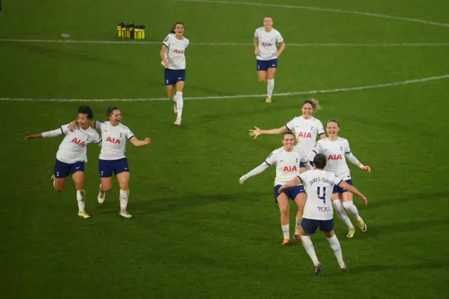 Spurs players run to celebrate their penalty shootout win.