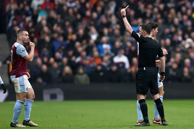 Referee Chris Kavanagh shows a red card to Aston Villa's Scottish midfielder John McGinn