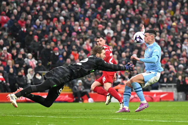 Caoimhin Kelleher of Liverpool makes a save whilst under pressure from Phil Foden