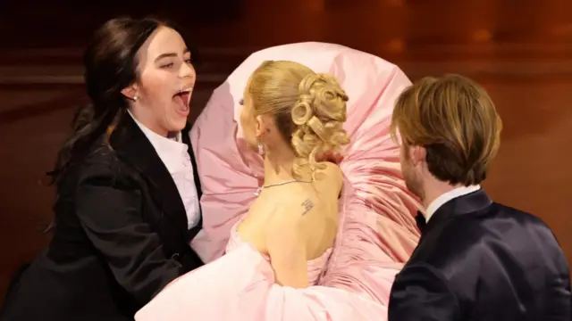 Billie Eilish and Finneas O'Connell celebrate with presenter Ariana Grande as they win the Oscar for Best Original Song for "What Was I Made For?" from "Barbie" during the Oscars show at the 96th Academy Awards in Hollywood, Los Angeles, California, U.S., March 10, 2024