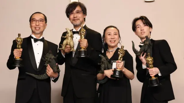 Masaki Takahashi, Takashi Yamazaki, Kiyoko Shibuya and Tatsuji Nojima, hold their Oscars and Godzilla figurines