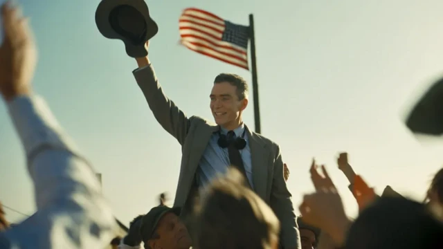 Cillian Murphy waves hit hat in a scene of Oppenheimer