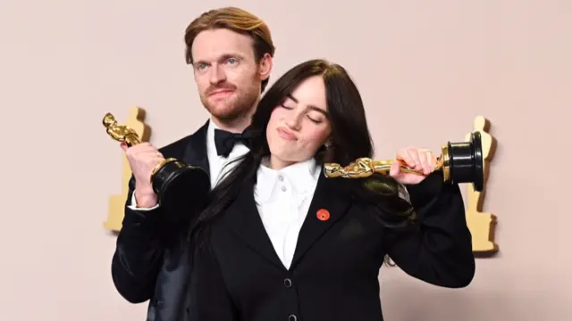 Sibling duo Finneas O'Connell and Billie Eilish pose with their Oscars