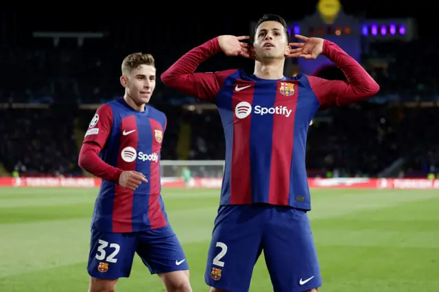 Cancelo cups his ears to the fans as he celebeates his goal.