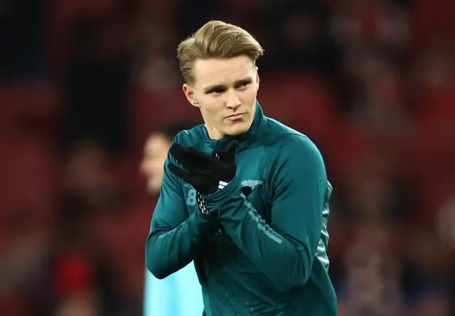 Odegaard claps the fans as he enters the pitch for the warm up.