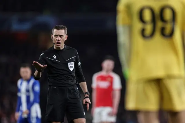 The referee gestures his decision at the playrs.