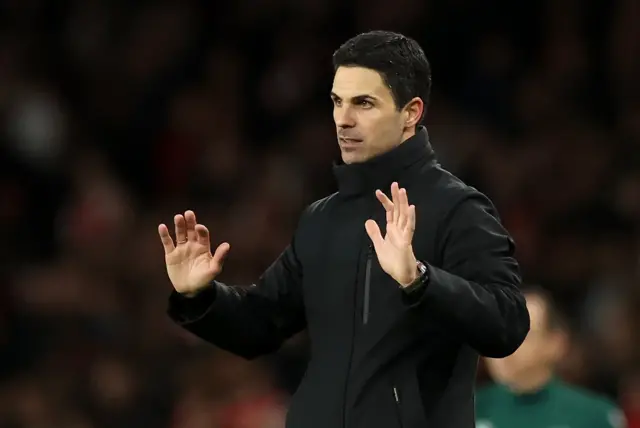 Arteta waves his arms.