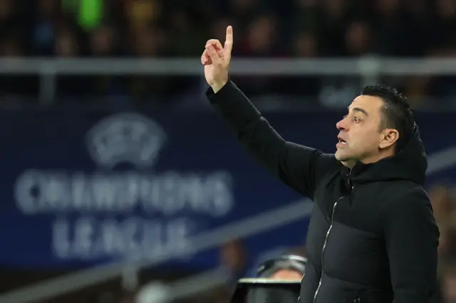 Xavi points to his players from the touchline.