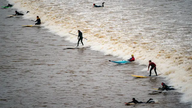 Surfers on the bore