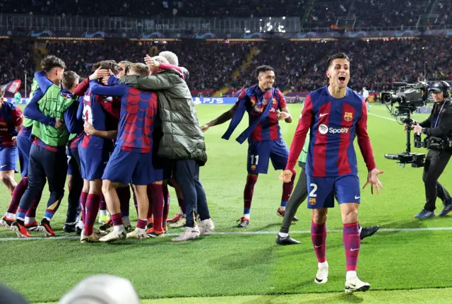 Cancelo celebrates with teh fans as his teammates gather behind.