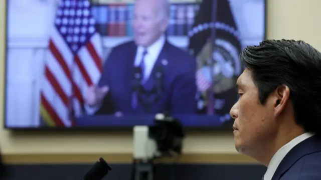 Special Counsel Robert Hur listens as a press conference featuring U.S. President Joe Biden plays in the background during Hur’s testimony in a House Judiciary Committee hearing about his inquiry into President Biden's handling of classified documents, on Capitol Hill in Washington, U.S., March 12, 2024