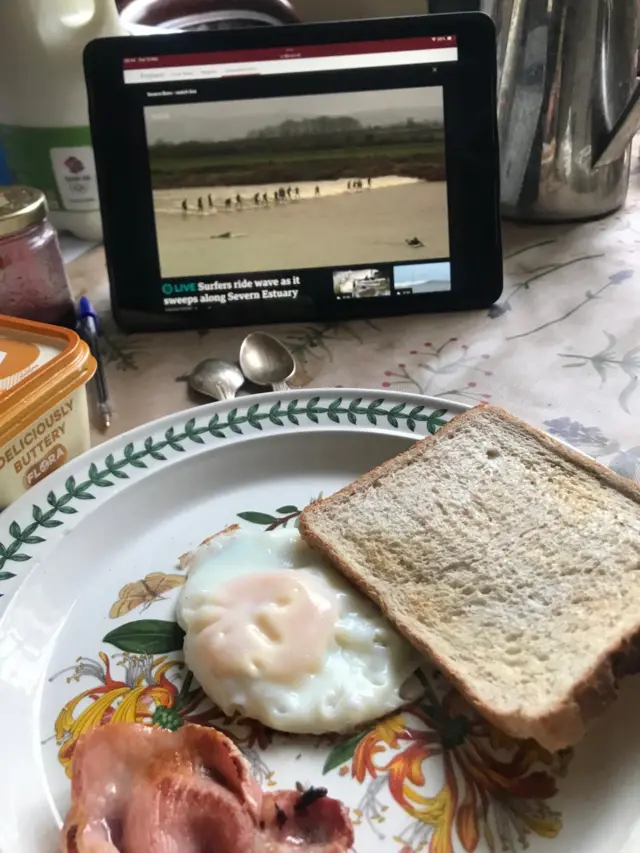 Paul Barnett watching the BBC's live stream of the Severn Bore while eating his breakfast