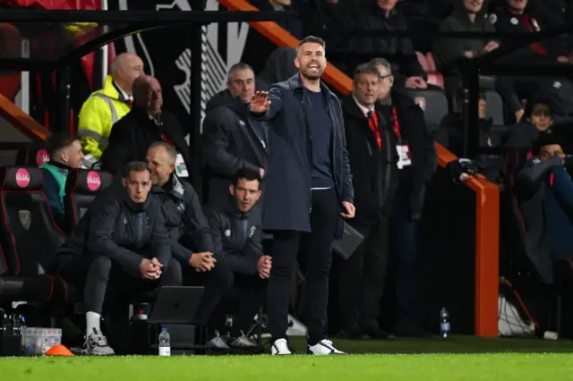 Edwards waves his hands to urge his side to calm down from his position on the touchline.