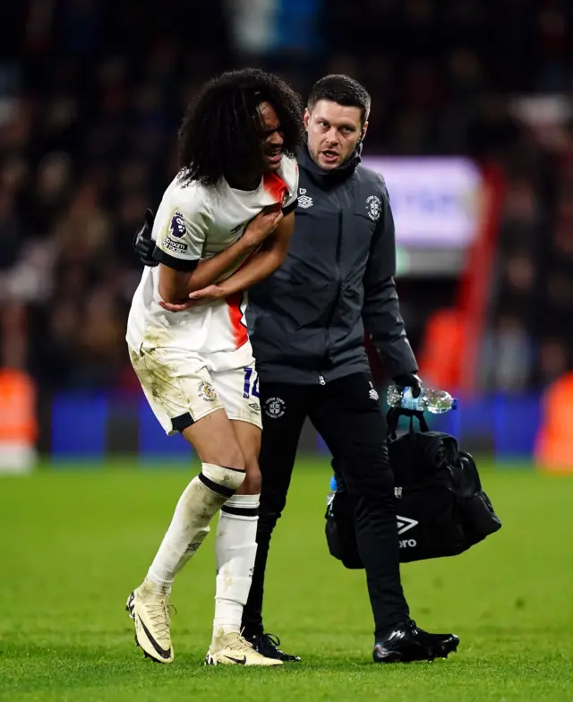 Chong is helped off by a physio after hurting his shoulder.