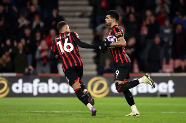 Solanke high fives Tavernier as he runs back to kick off with the ball.