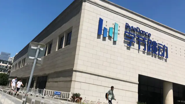 People walk past the Bytedance headquarters building in Beijing, China, August 3, 2020.