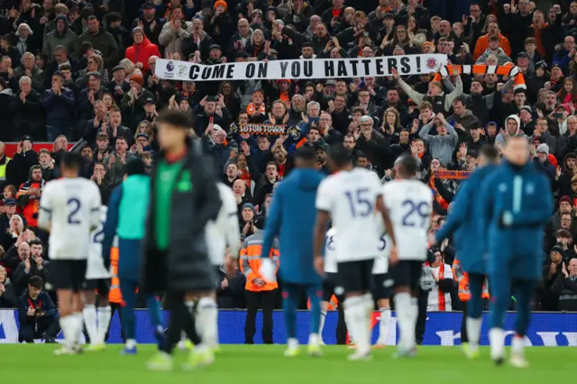 Luton players clap their away fans at full time.