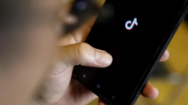 A man uses TikTok on his phone at a cafe in Hanoi, Vietnam 06 April 2023. Vietnam will inspect social media app TikTok to prevent 'toxic content', according to Ministry of Information and Communications.