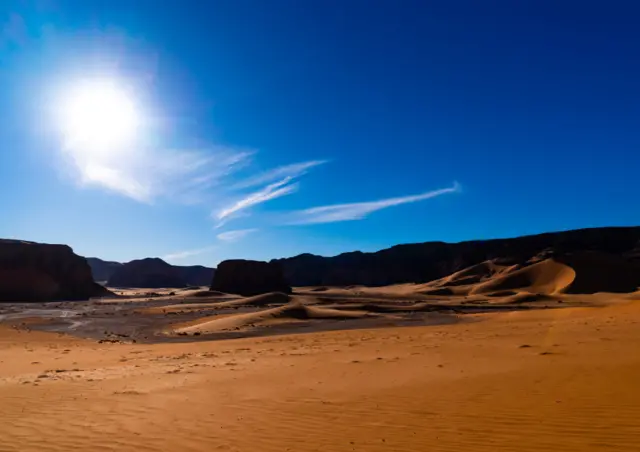 Rocks and sand dunes in Sahara desert, Tassili N'Ajjer National Park, Tadrart Rouge, Algeria on December 30, 2022