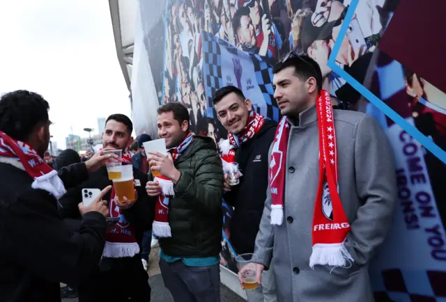 Frieburg fans drink pints outside London Stadium.