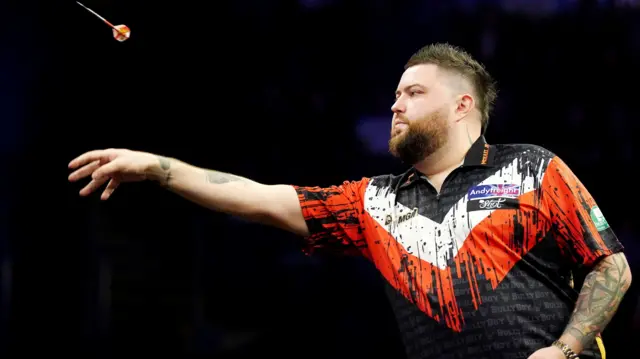 Michael Smith throws a dart