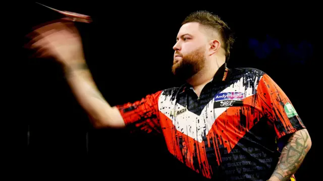 Michael Smith throws a dart