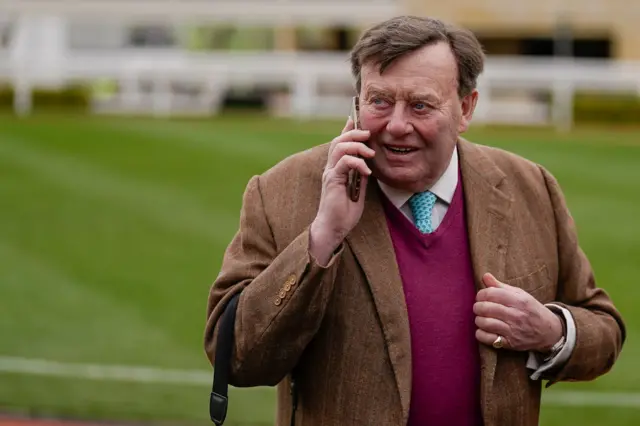 Nicky Henderson talks on his phone at Cheltenham