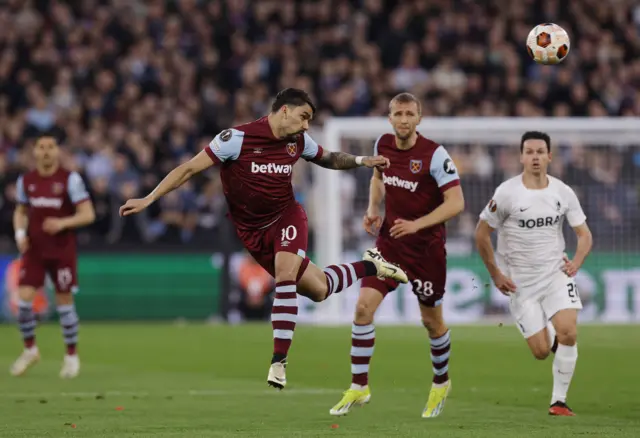 Paqueta heads the ball in midfield.