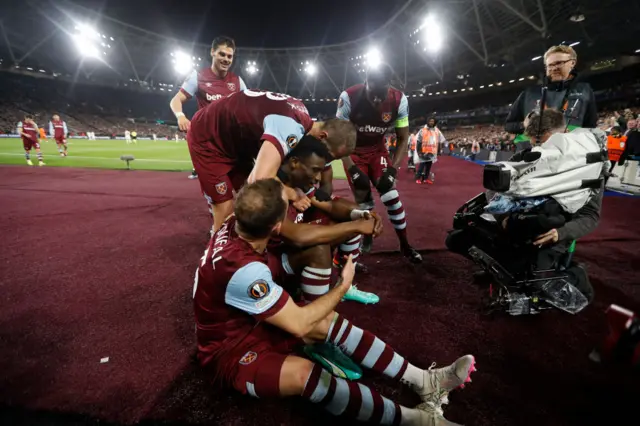 Kudus sits ona stool and is mobbed by teammates