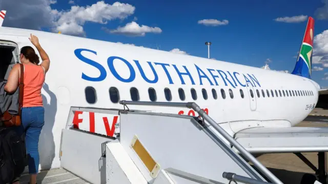 A passenger boards a South African Airways (SAA) plane at the Hosea Kutako International Airport, in Windhoek, Namibia, February 24, 2023