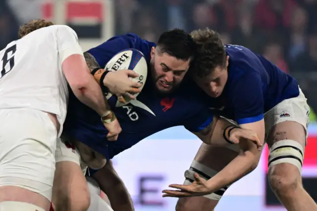 French player running whilst being tackled