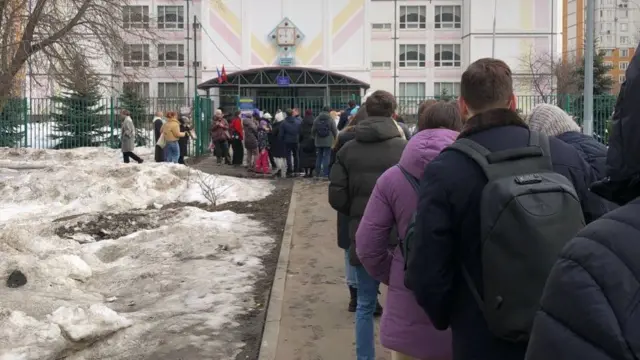 People are gathering in front a polling station in Moscow at 1200