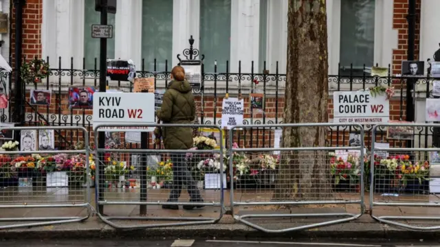 A person looks at flowers laid for Alexei Navalny opposite the Russian embassy in London.