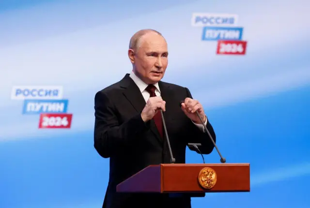 Russian presidential candidate and incumbent President Vladimir Putin speaks after polling stations closed on the final day of the presidential election