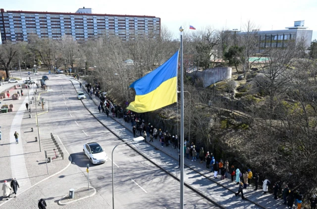 Russians living in Sweden queue at lunchtime outside the Russian embassy in Stockholm to vote on 17 March 2024.