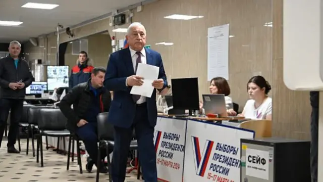 Russian Communist Party presidential candidate Nikolai Kharitonov walks to cast his ballot in Russia's presidential election at a polling station in Moscow